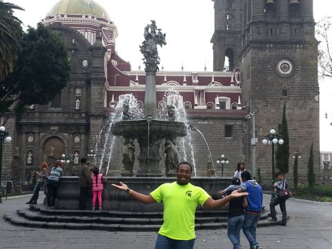 man in spartan shirt in front of fountain in Mexico